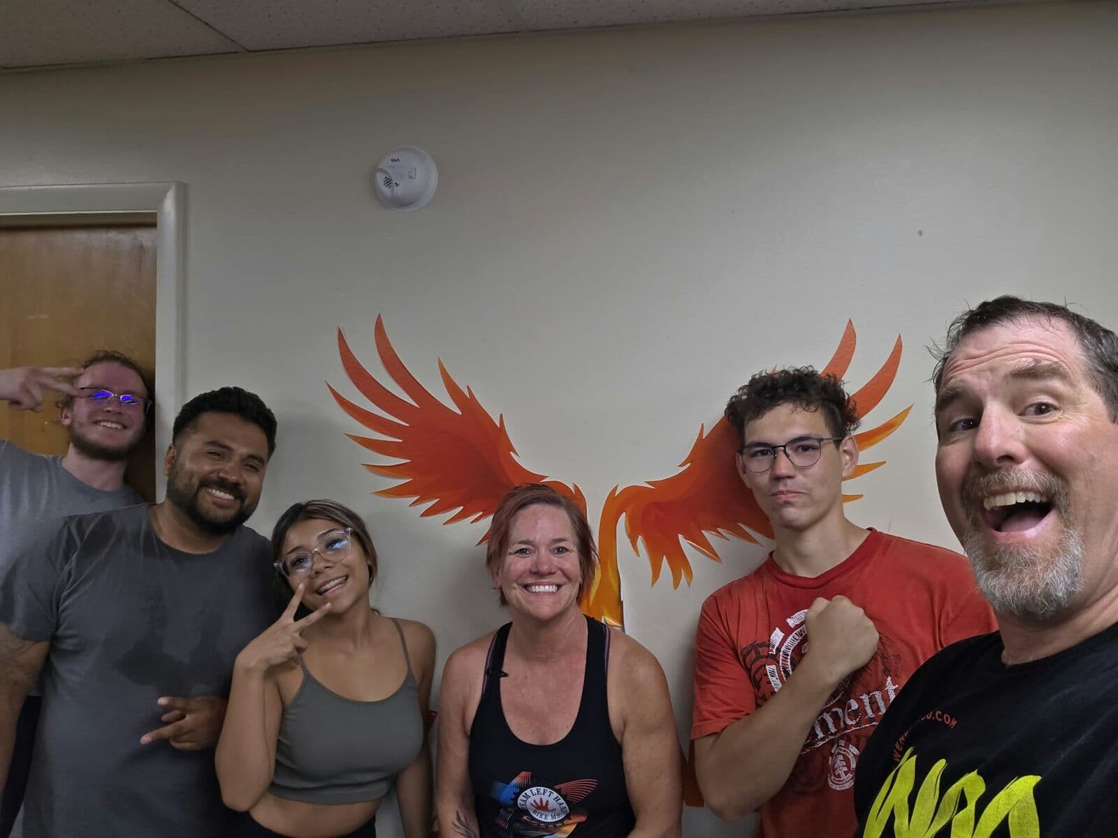Group selfie of smiling members in front of the FYR phoenix