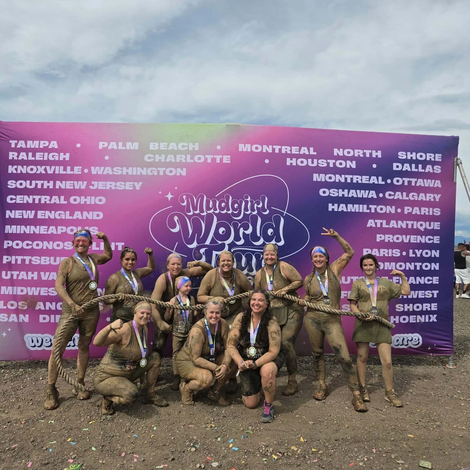 Mud-covered team with medals after a Mudgirl race